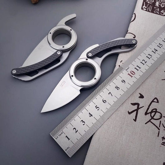 Two DefendGear AegisOrbit ring folding knives shown beside a metric ruler